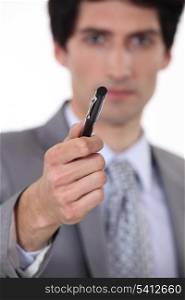 businessman holding out pen for signature