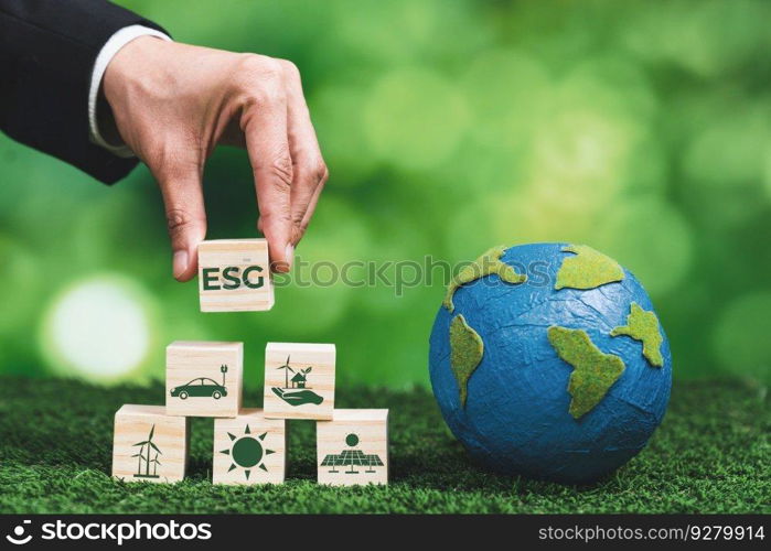 Businessman holding paper earth planet with ESG symbol wooden cube. Sustainable corporation development for environmental, social and governance idea to save the earth. Alter. Businessman holding paper earth planet with ESG symbol wooden cube. Alter