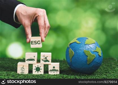 Businessman holding paper earth planet with ESG symbol wooden cube. Sustainable corporation development for environmental, social and governance idea to save the earth. Alter. Businessman holding paper earth planet with ESG symbol wooden cube. Alter