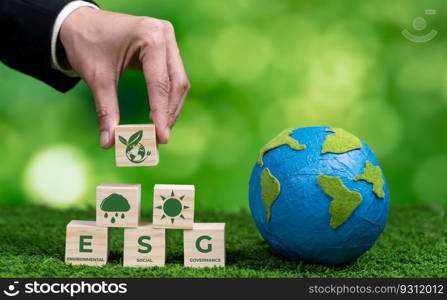 Businessman holding paper earth planet with ESG symbol wooden cube. Sustainable corporation development for environmental, social and governance idea to save the earth. Alter. Businessman holding paper earth planet with ESG symbol wooden cube. Alter