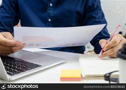 Businessman holding paperwork document graph report accounting and finance investment on desk