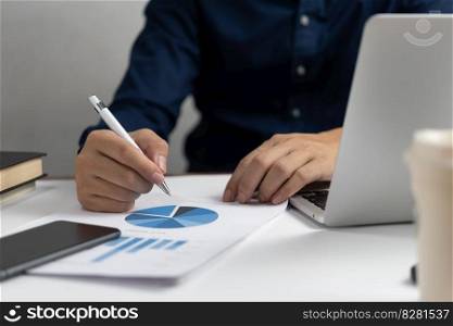 Businessman holding pen document graph and chart holding pen accounting marketing with computer laptop.
