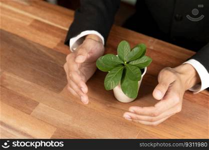 Businessman holding plant pot with his hand promoting forest regeneration and natural awareness. Ethical green business with eco-friendly policy utilizing renewable energy to preserve ecology. Alter. Businessman holding plant pot with his hand promoting forest regeneration. Alter