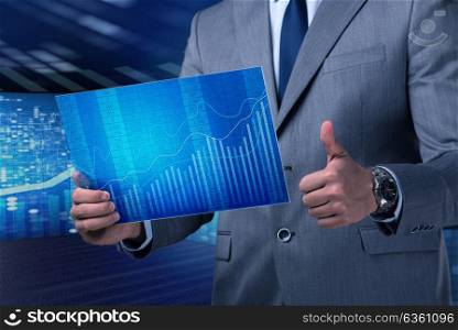 Businessman holding screen with market quotes
