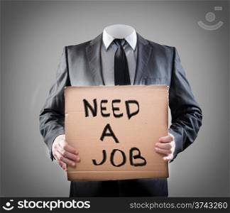 "Businessman holding sign "need a job""