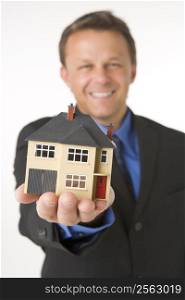 Businessman Holding Small House