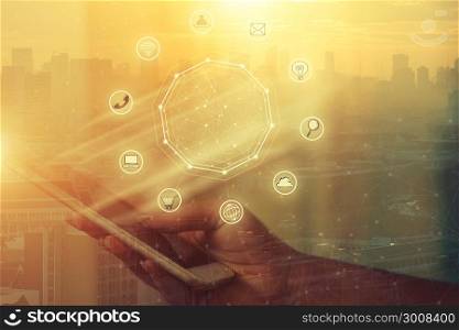 Businessman holding smart phone with wireless communication network icon and cityscape background. E-commerce smart connection business. internet of things.