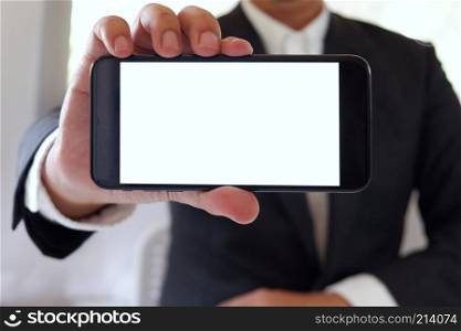 Businessman holding smartphone forward empty white screen for your text or picture