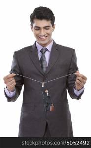 Businessman holding string from which another businessman hangs