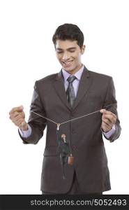 Businessman holding string from which another businessman hangs