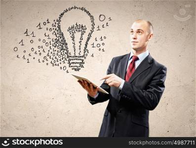 Businessman holding tablet pc. Young businessman holding tablet pc thinking over idea