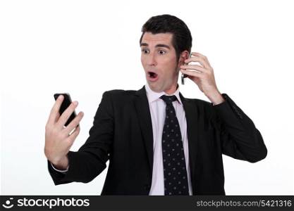 Businessman holding two cell phones