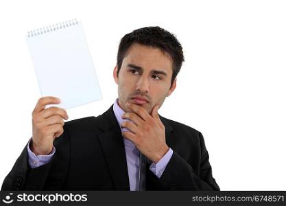 Businessman holding up a blank notepad