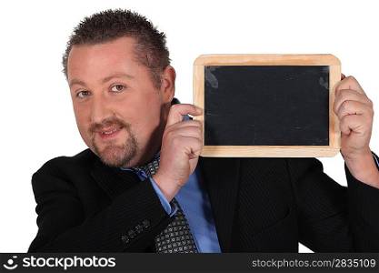 Businessman holding up a chalkboard