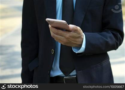 Businessman holding using mobile smart phone