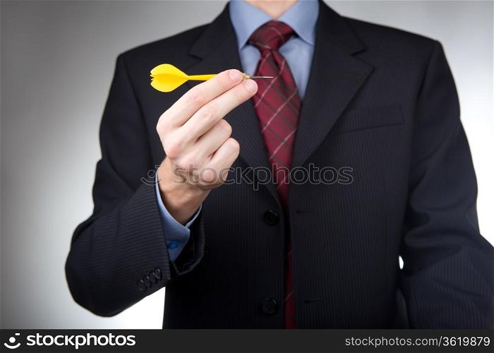 Businessman holding yellow dart