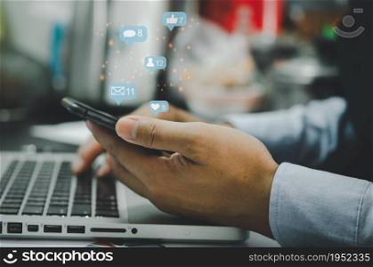 businessman holds a phone and uses social media for internet marketing. Concept of business technology with notification icons of like, message, email, comment smartphone screen