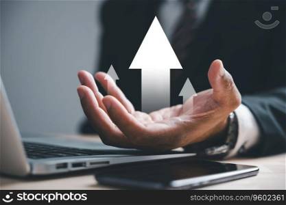 Businessman holds arrow graph on palm with laptop computer, depicting development to success and growing growth concept. Corporate future growth plan in hand illustrates business strategy.