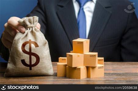 Businessman holds dollar money bag and boxes with goods. Purchase and sale of goods, trade and commerce. Import and export. Business income. Payment of taxes and fees. Advertising budget