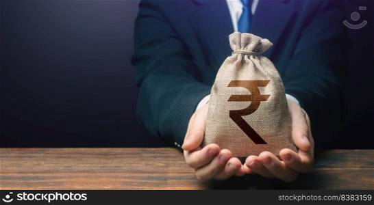Businessman holds out indian rupee money bag. Getting a grant. Easy Money. Salary, benefits, profit. Attracting investments. Deposit savings. Cashback. Banking and crediting. Mortgage, loan approval.