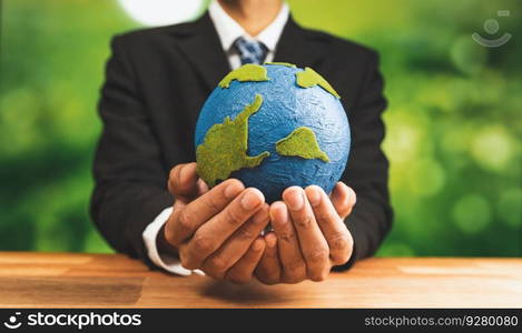 Businessman holds paper earth as symbol of eco environmental awareness for sustainable world using clean energy and zero CO2 emission. Eco-friendly corporate with go green policy to save earth. Alter. Businessman holds paper earth as symbol of eco environmental awareness. Alter