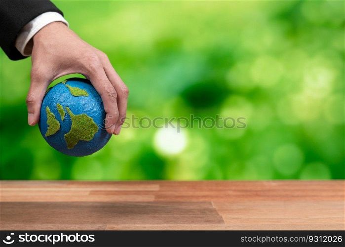 Businessman holds paper earth as symbol of eco environmental awareness for sustainable world using clean energy and zero CO2 emission. Eco-friendly corporate with go green policy to save earth. Alter. Businessman holds paper earth as symbol of eco environmental awareness. Alter