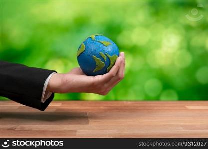 Businessman holds paper earth as symbol of eco environmental awareness for sustainable world using clean energy and zero CO2 emission. Eco-friendly corporate with go green policy to save earth. Alter. Businessman holds paper earth as symbol of eco environmental awareness. Alter