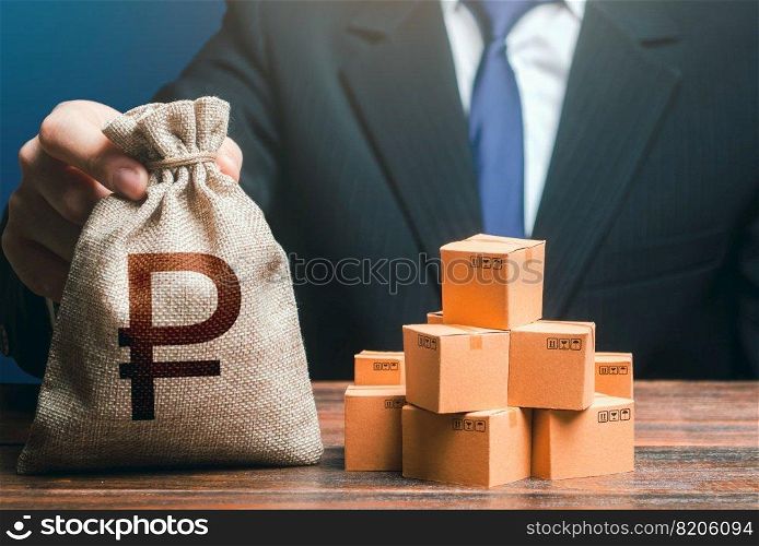 Businessman holds russian ruble money bag and boxes with goods. Import and export. Purchase and sale of goods, trade and commerce. Business income. Payment of taxes and fees. Advertising budget