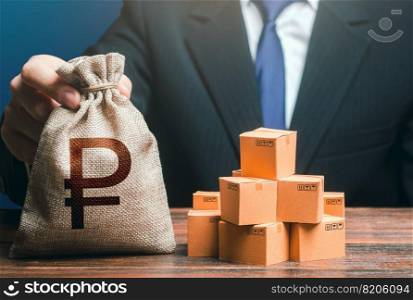 Businessman holds russian ruble money bag and boxes with goods. Import and export. Purchase and sale of goods, trade and commerce. Business income. Payment of taxes and fees. Advertising budget