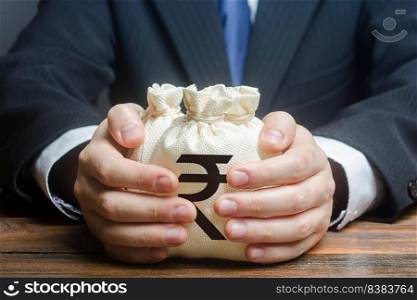 Businessman hugs indian rupee money bags. Granting financing business project or education. Trade, economics. Corruption. Provision financial loan credit. Bank deposit. Budget, tax collection.
