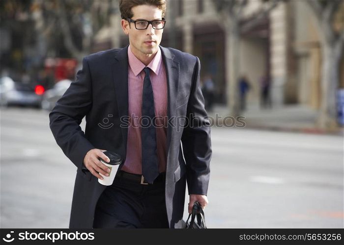 Businessman Hurrying Along Street Holding Takeaway Coffee