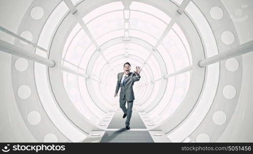 Businessman in 3D room mixed media. Young businessman running in futuristically designed tunnel