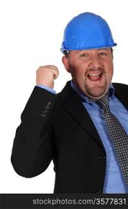 Businessman in a hardhat with his fist in the air