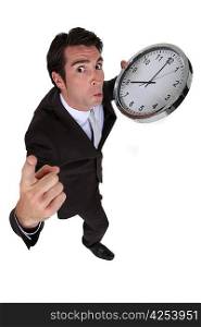 businessman in a hurry holding a huge clock