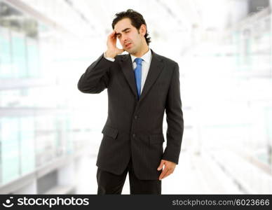 Businessman in a suit gestures with a headache