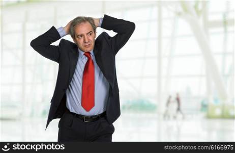 Businessman in a suit gestures with a headache at the office