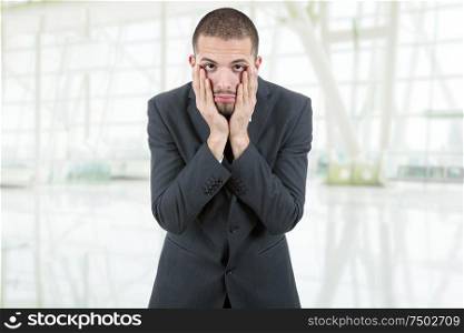 Businessman in a suit gestures with a headache at the office
