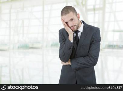Businessman in a suit gestures with a headache at the office. headache