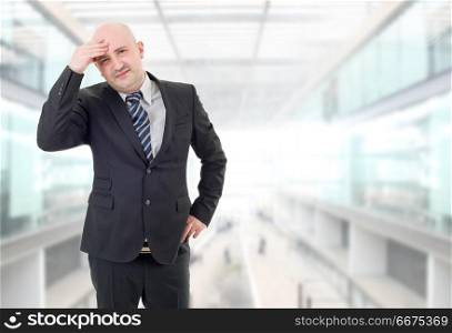 Businessman in a suit gestures with a headache, at the office. headache