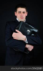 Businessman in a suit holds a briefcase
