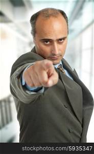 Businessman in a suit pointing, focus on the face