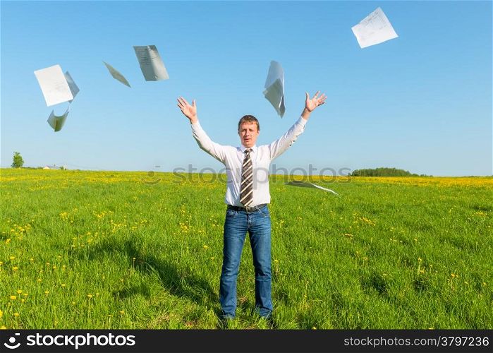 businessman in a tie throwing papers in the field