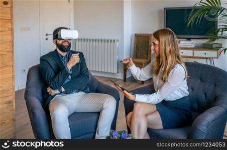 Businessman in an informal work meeting using virtual reality glasses. Businessman using virtual reality glasses