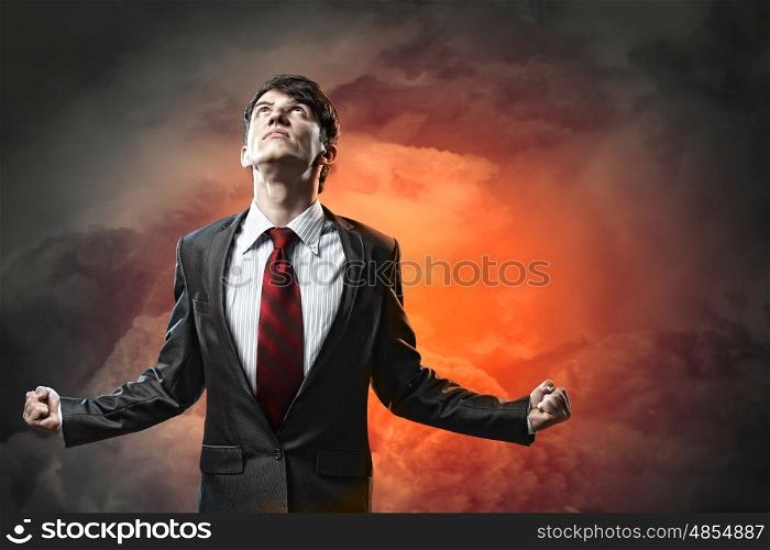 businessman in anger. businessman in anger with fists clenched looking in the sky