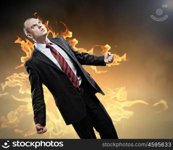 Businessman in anger. Image of young businessman in anger burning in fire