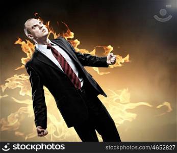 Businessman in anger. Image of young businessman in anger burning in fire