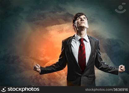 businessman in anger with fists clenched looking in the sky