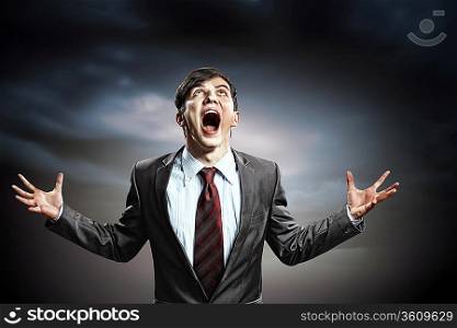 businessman in anger with fists clenched screaming