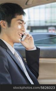 Businessman in Back Seat of Car on the Phone