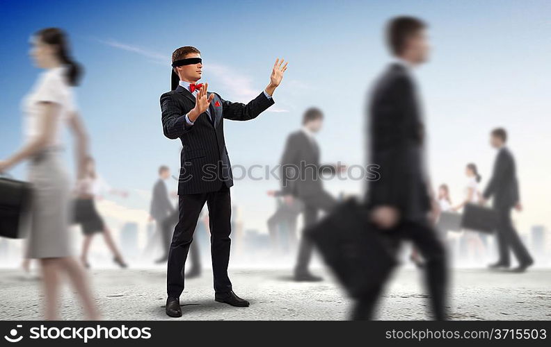 Businessman in blindfold among group of people